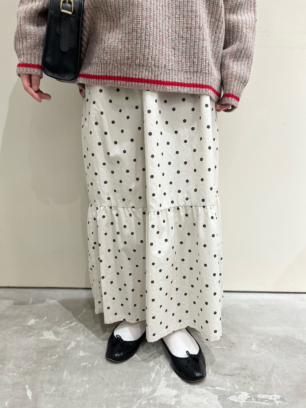 ホワイト系のTシャツ/カットソー、ブラック系のショルダーバッグ、ホワイト系のスカートを着用したレディースの冬コーディネートの5枚目の写真