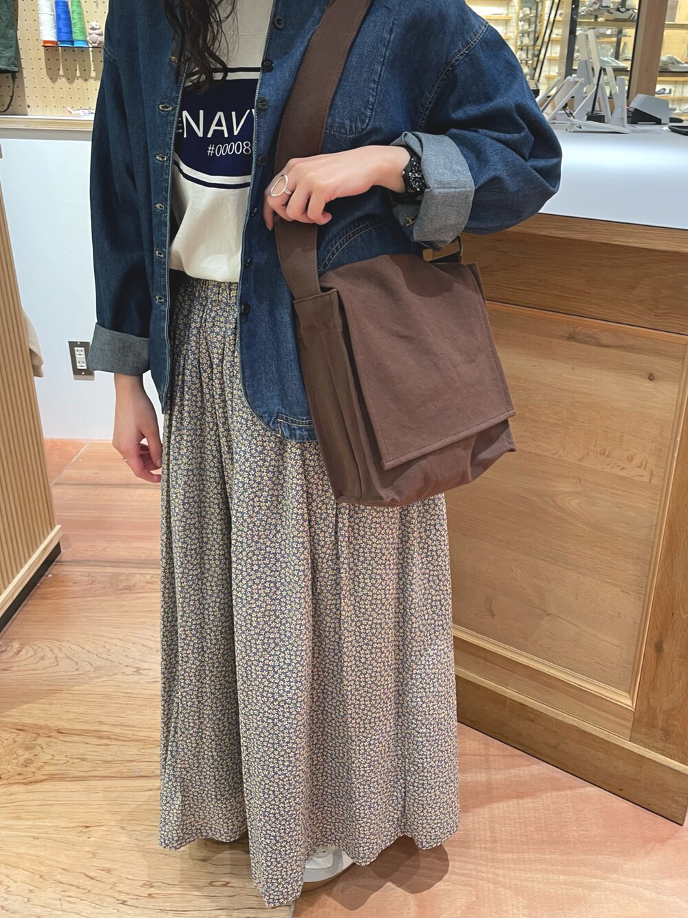 イエロー系のスカート、ブラウン系のショルダーバッグ、ブルー系のデニムジャケットを着用したレディースの春コーディネートの4枚目の写真