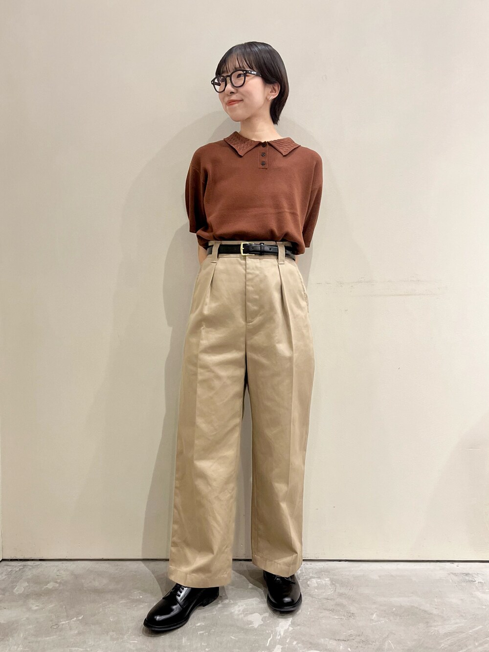 ブラウン系のポロシャツを着用したレディースの春コーディネートの5枚目の写真