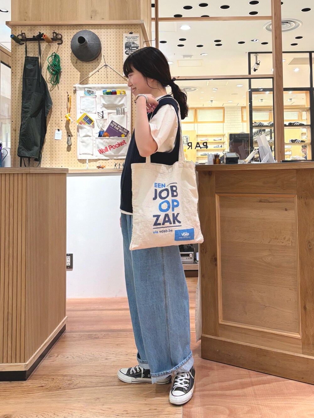 ブルー系のベスト、ホワイト系のTシャツ/カットソー、ブルー系のデニムパンツを着用したレディースの春コーディネートの3枚目の写真