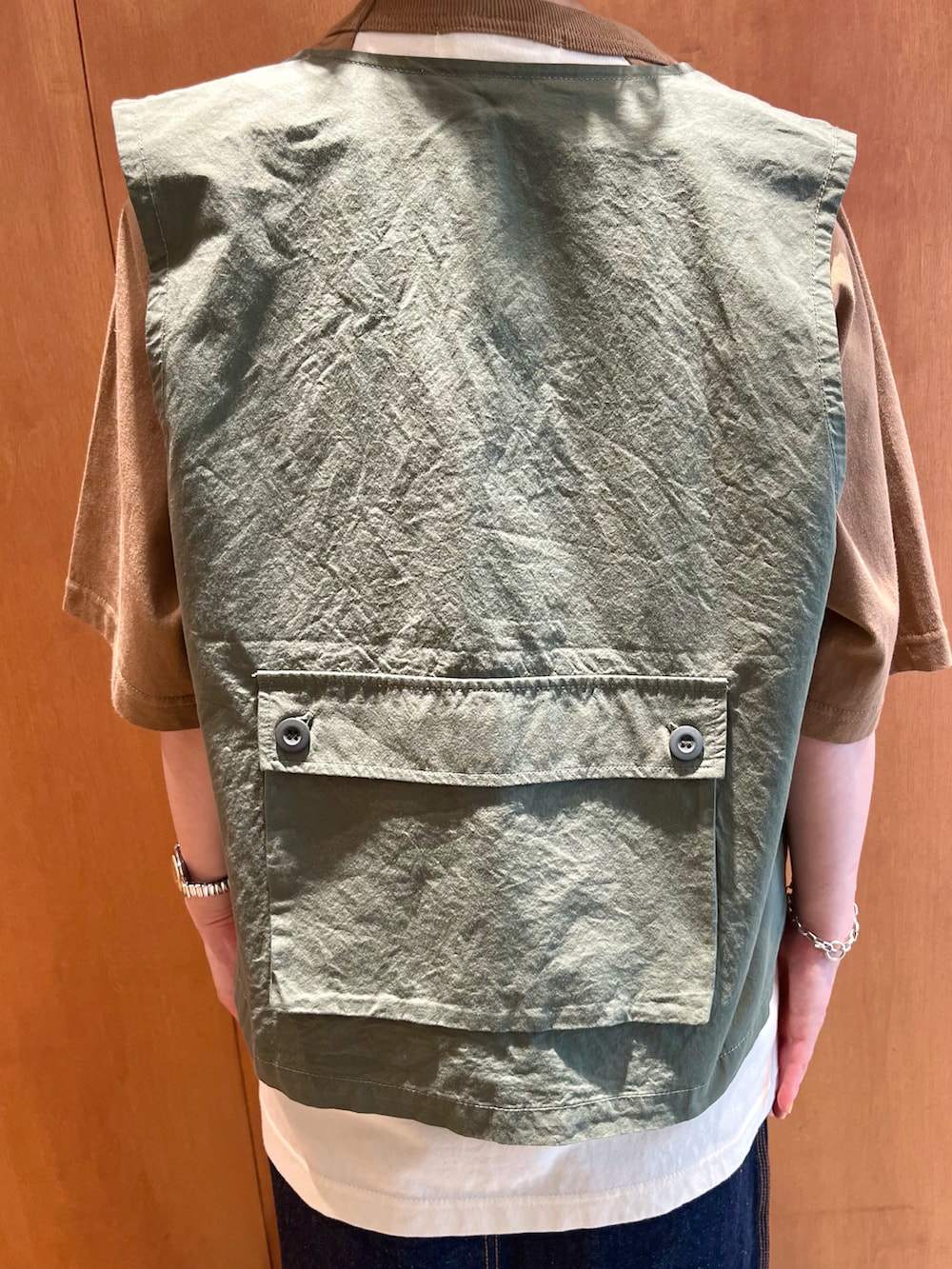 ブラウン系のTシャツ/カットソー、グリーン系のベスト、ブルー系のデニムスカートを着用したレディースの夏コーディネートの4枚目の写真