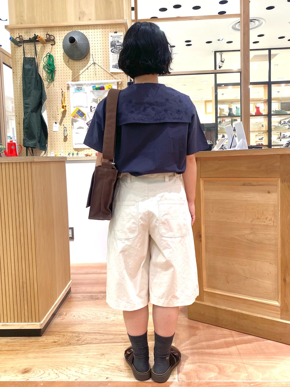 ブルー系のシャツ/ブラウス、ホワイト系のその他パンツ、ブラウン系のショルダーバッグを着用したレディースの夏コーディネートの3枚目の写真