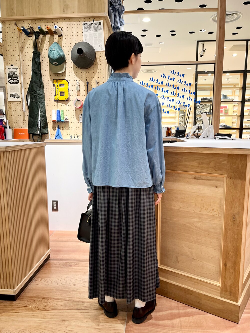 ブルー系のシャツ/ブラウス、グレー系のスカート、ブラック系のショルダーバッグを着用したレディースの秋コーディネートの3枚目の写真