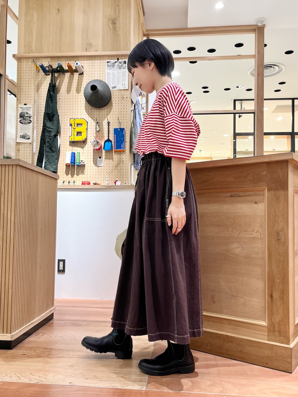 レッド系のTシャツ/カットソー、ブラウン系のスカートを着用したレディースの夏コーディネートの3枚目の写真