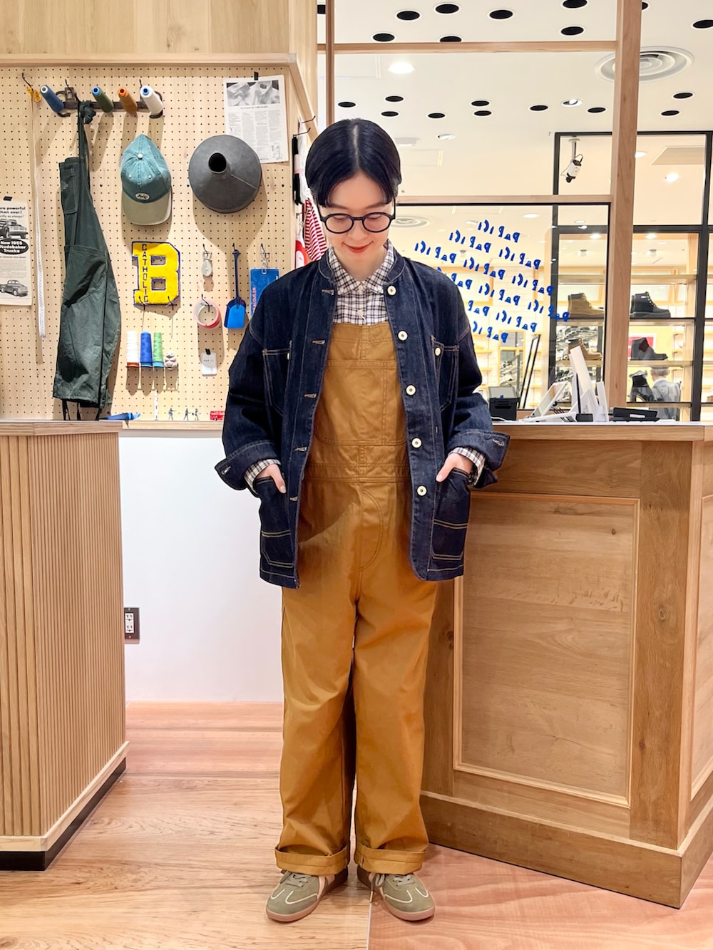 ブルー系のシャツ/ブラウス、ブルー系のカバーオール、ブラウン系のサロペット/オーバーオールを着用したレディースの秋コーディネートの2枚目の写真