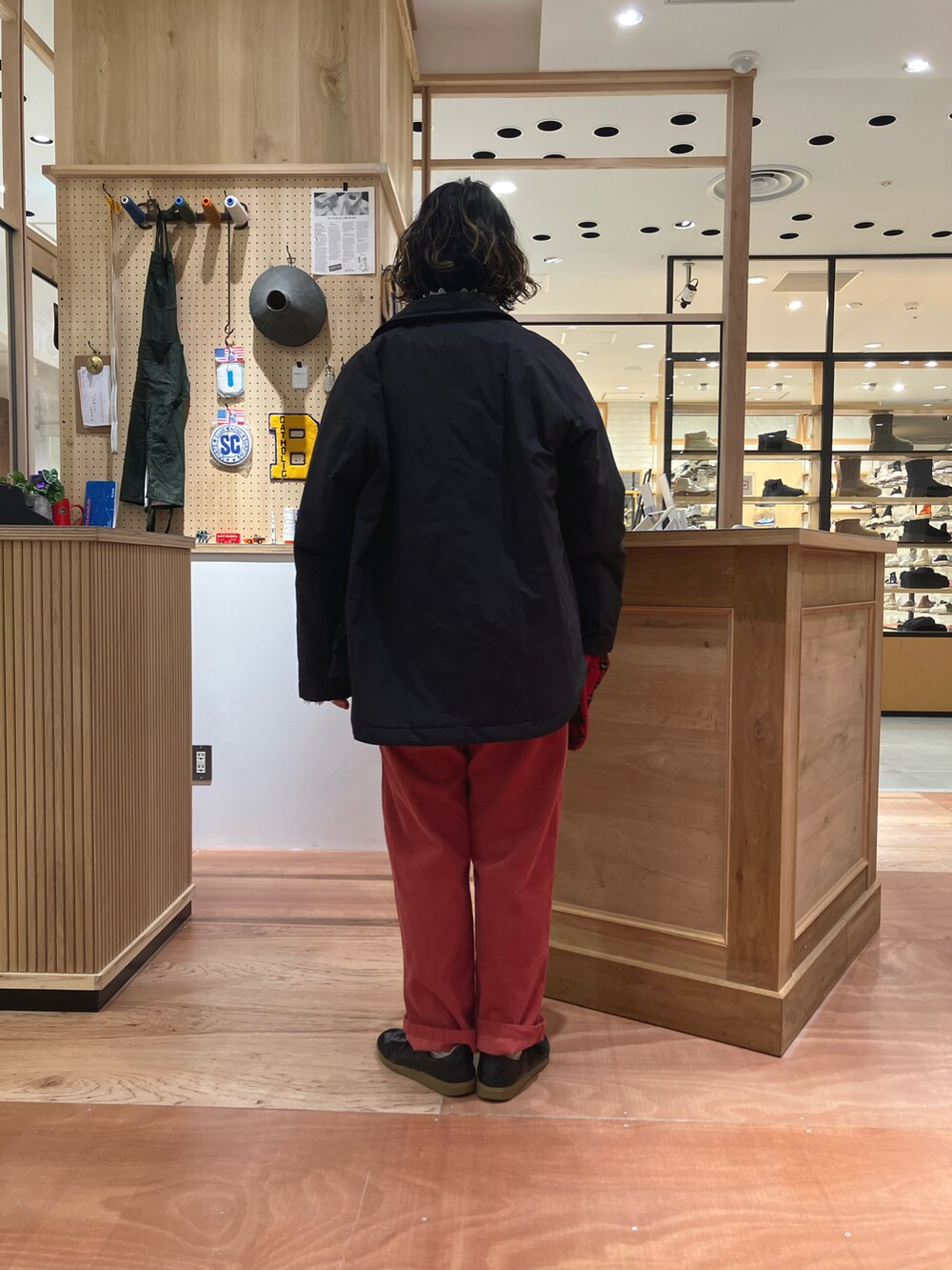 ブラック系のブルゾン、ホワイト系のシャツ/ブラウス、ブルー系のベストを着用したレディースの秋コーディネートの3枚目の写真