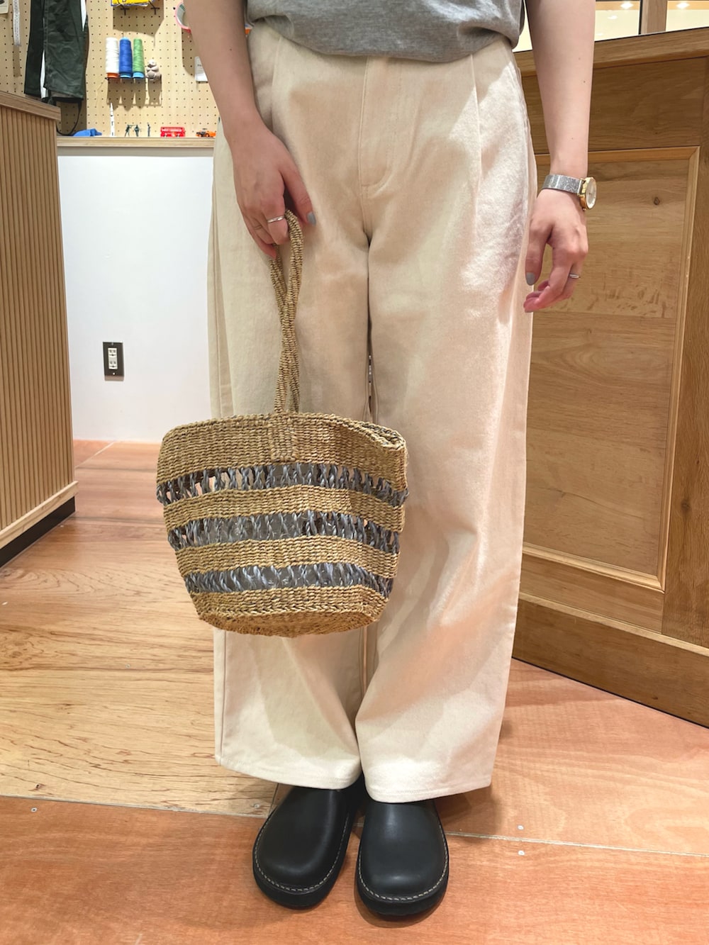 グレー系のTシャツ/カットソー、ホワイト系のその他パンツ、グレー系のかごバッグを着用したレディースの春コーディネートの4枚目の写真
