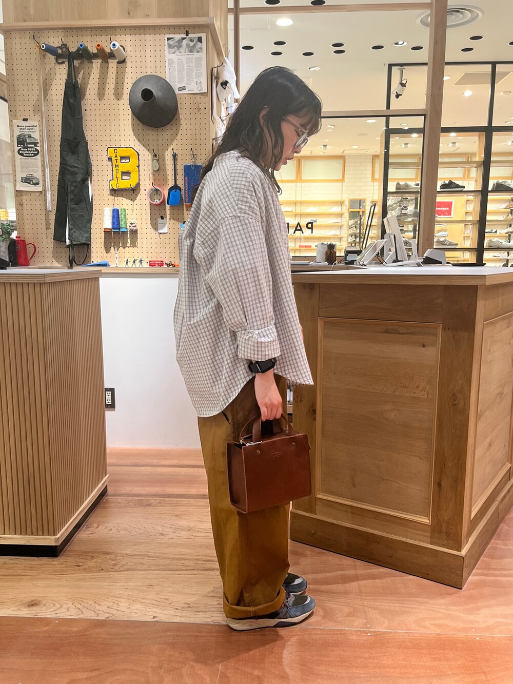 ブラウン系のサロペット/オーバーオール、ホワイト系のシャツ/ブラウス、グレー系のTシャツ/カットソーを着用したレディースの春コーディネートの2枚目の写真