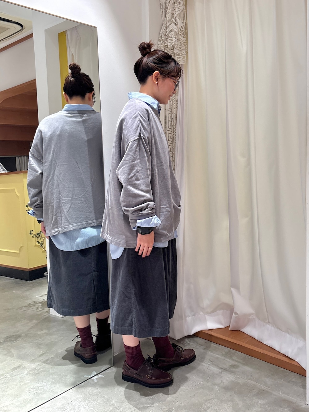 ブルー系のシャツ/ブラウス、グレー系のTシャツ/カットソー、グレー系のスカートを着用したレディースの秋コーディネートの2枚目の写真