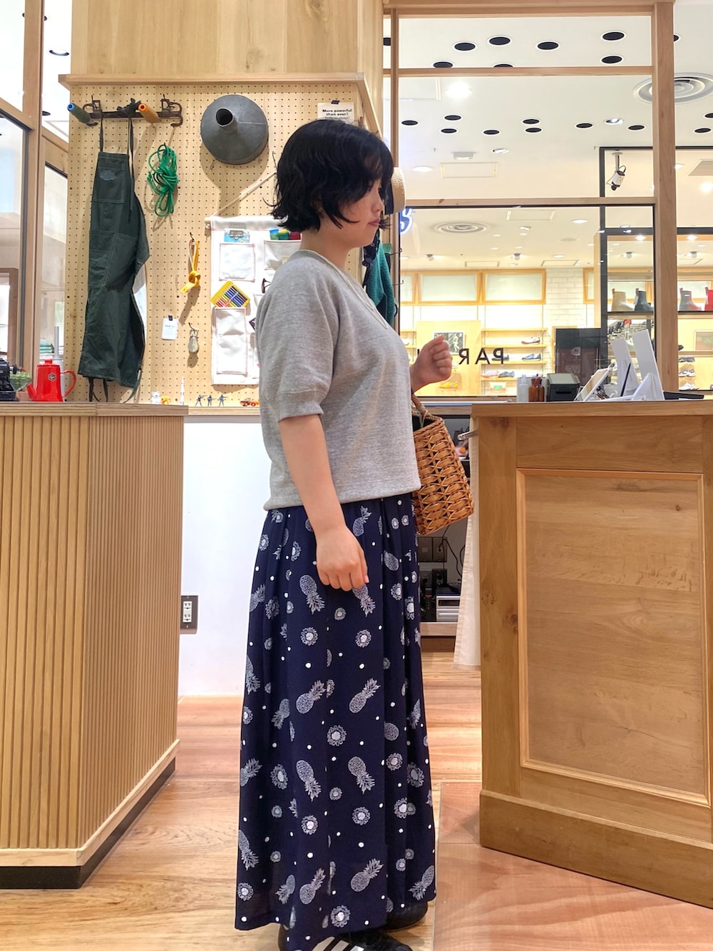 ブルー系のスカート、グレー系のTシャツ/カットソー、ホワイト系のネックレスを着用したレディースの夏コーディネートの2枚目の写真
