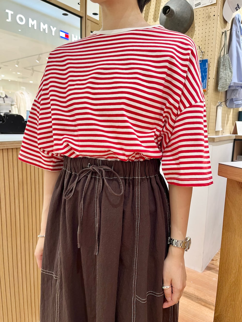 レッド系のTシャツ/カットソー、ブラウン系のスカートを着用したレディースの夏コーディネートの4枚目の写真