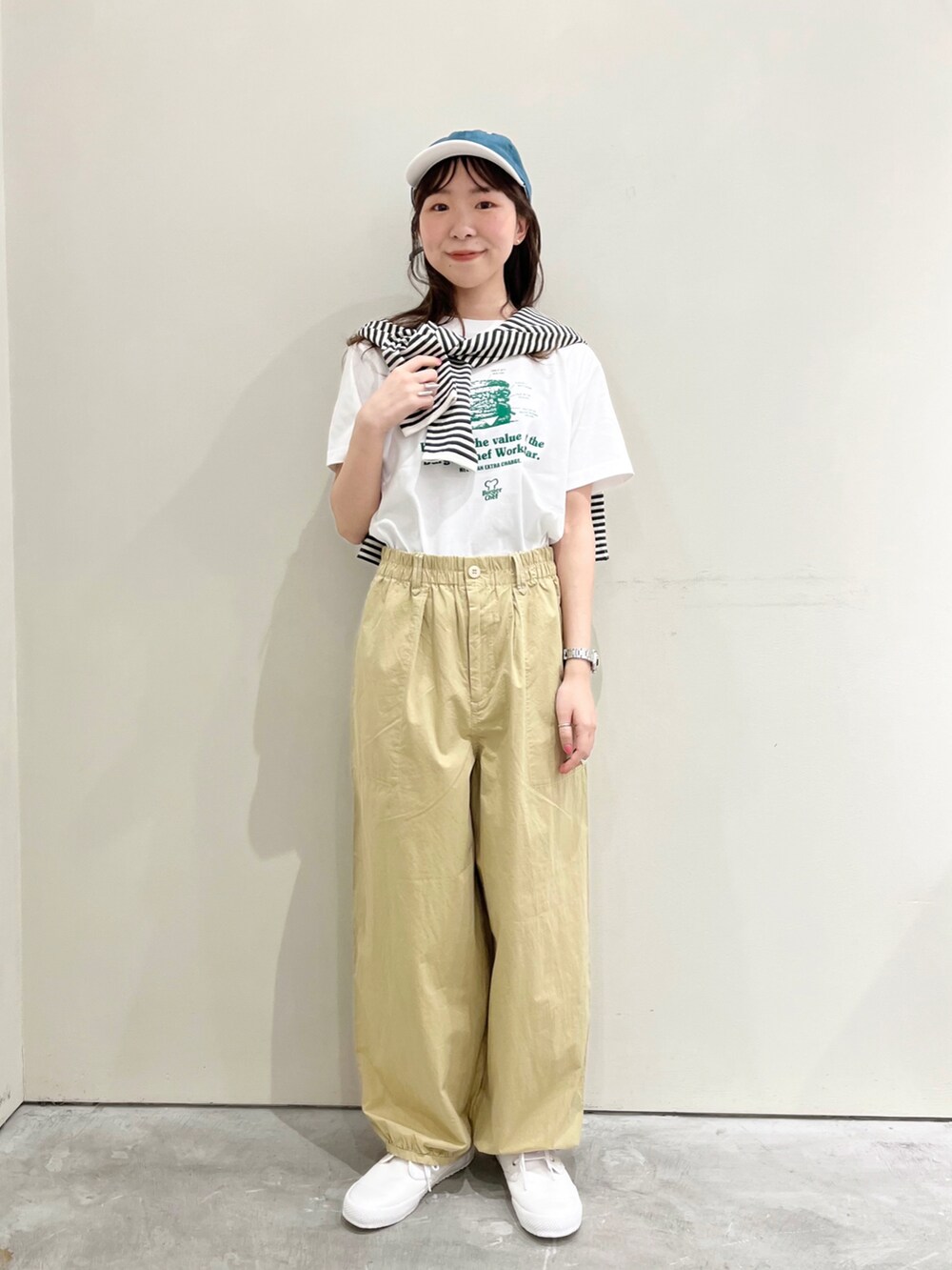 ホワイト系のTシャツ/カットソー、ベージュ系のその他パンツ、ホワイト系のスニーカーを着用したレディースの春コーディネートの2枚目の写真