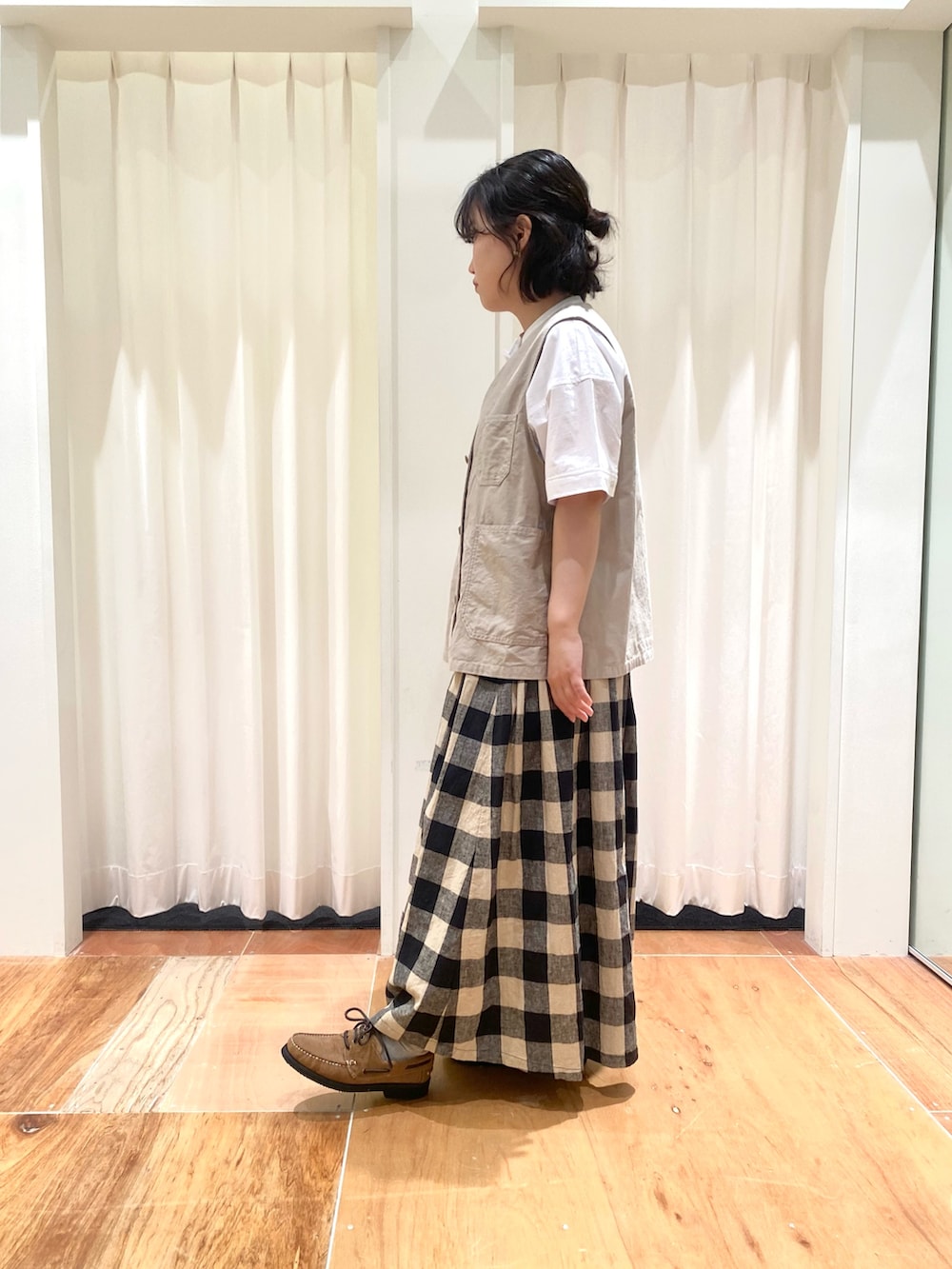 ホワイト系のシャツ/ブラウス、ベージュ系のベスト、ブラック系のスカートを着用したレディースの夏コーディネートの2枚目の写真