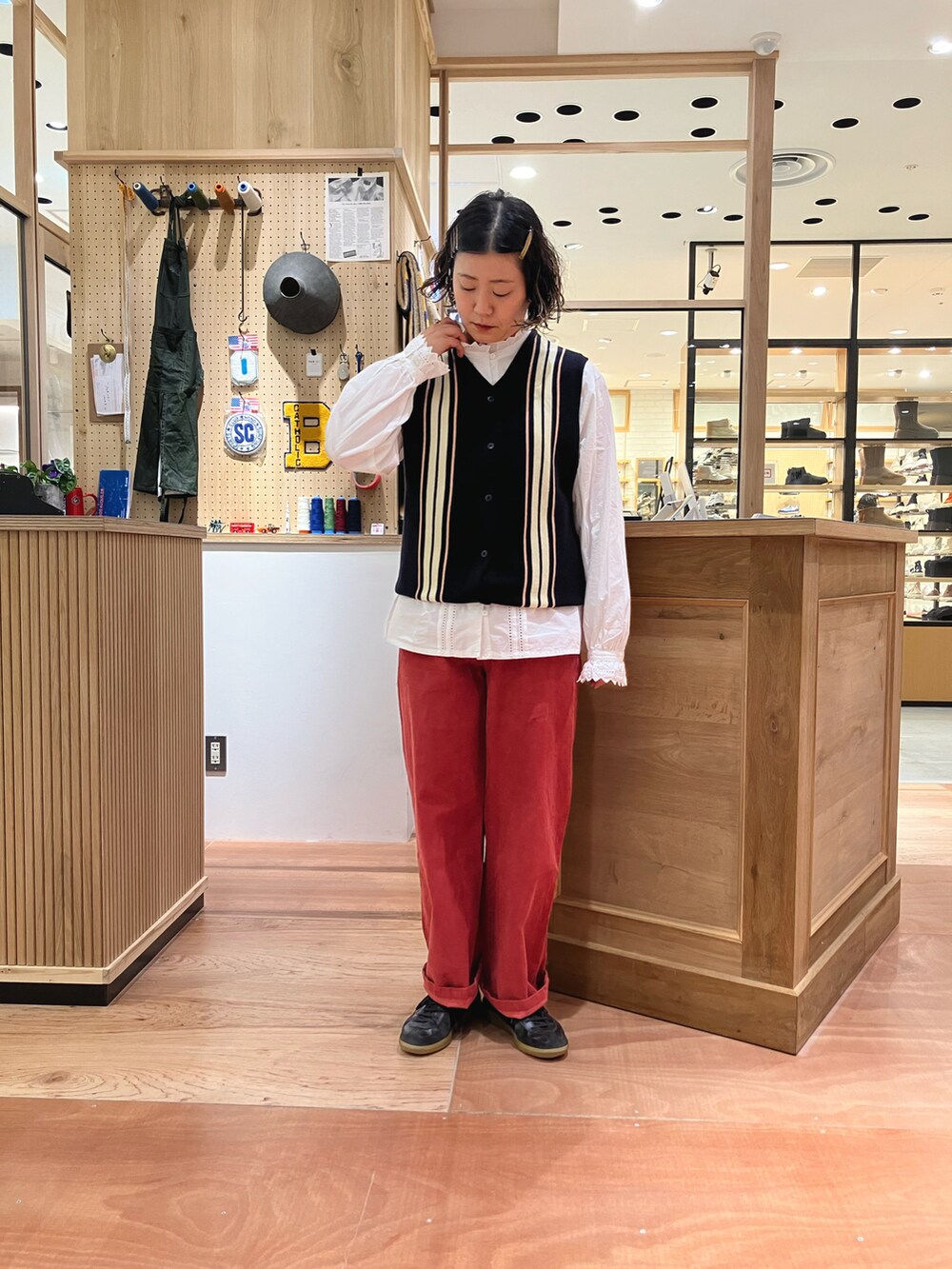 ブラック系のブルゾン、ホワイト系のシャツ/ブラウス、ブルー系のベストを着用したレディースの秋コーディネートの5枚目の写真