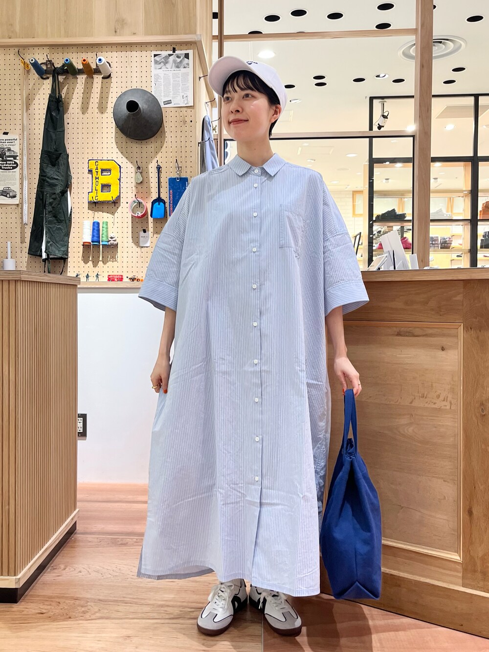 ブルー系のシャツワンピース、ブルー系のトートバッグを着用したレディースの夏コーディネートの2枚目の写真