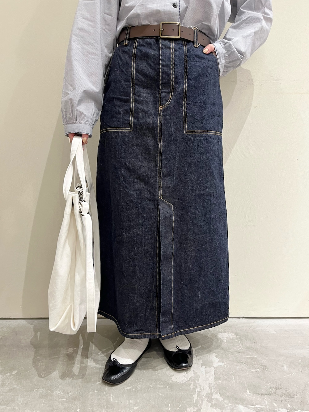 ブルー系のシャツ/ブラウス、ブルー系のデニムスカート、ホワイト系のトートバッグを着用したレディースの冬コーディネートの5枚目の写真