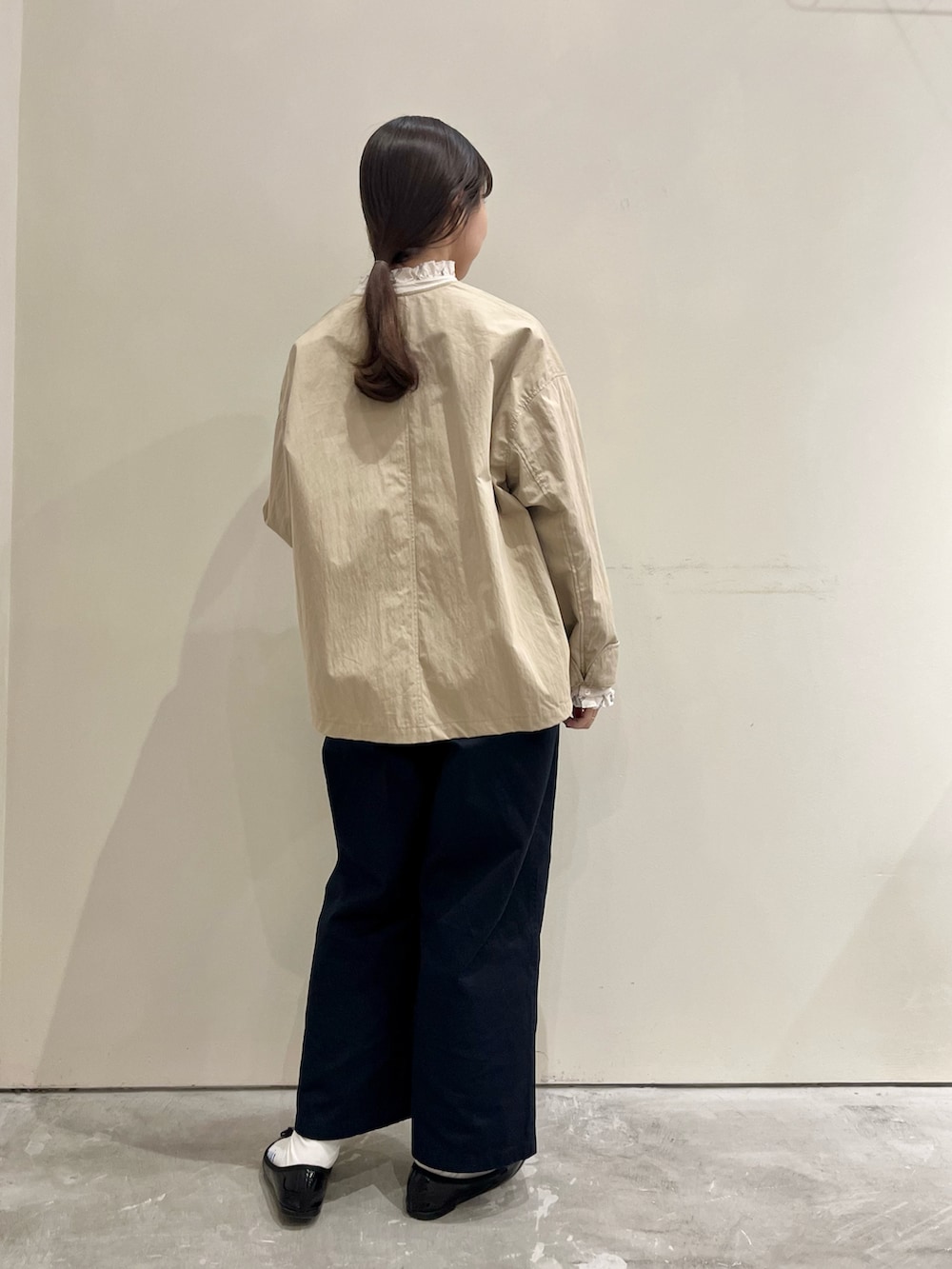 ベージュ系のシャツ/ブラウス、ベージュ系のノーカラージャケット、ブルー系のチノパンツを着用したレディースの秋コーディネートの3枚目の写真