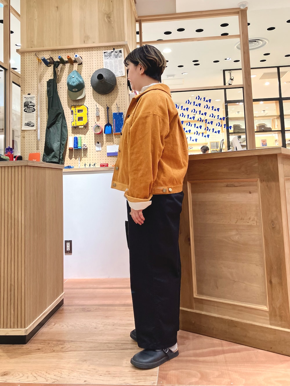 オレンジ系のブルゾン、ベージュ系のシャツ/ブラウス、ブラック系のその他パンツを着用したレディースの秋コーディネートの2枚目の写真