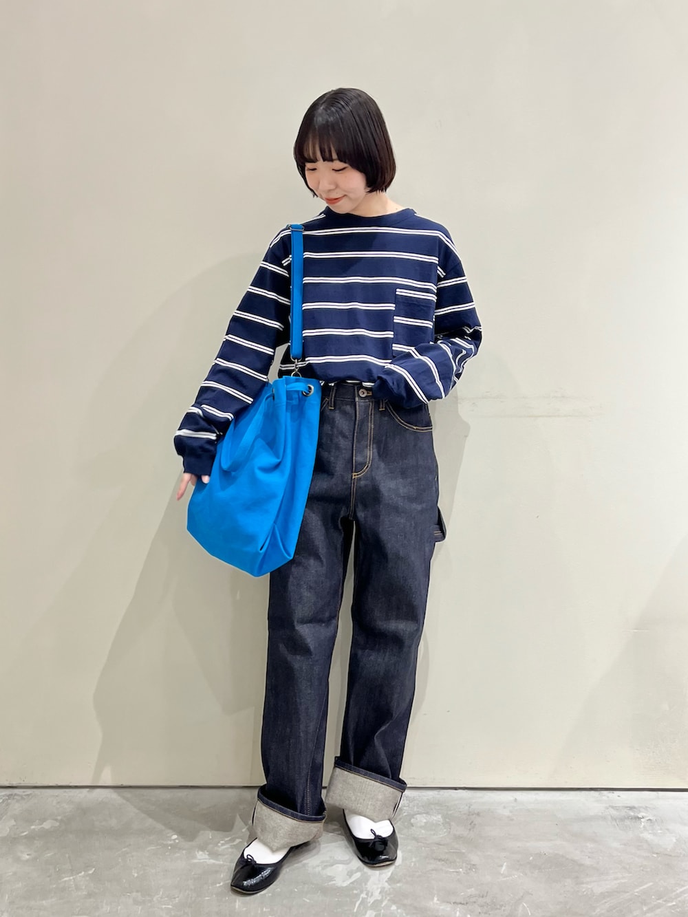 ブルー系のTシャツ/カットソー、ブルー系のデニムパンツ、ブルー系のトートバッグを着用したレディースの秋コーディネートの2枚目の写真