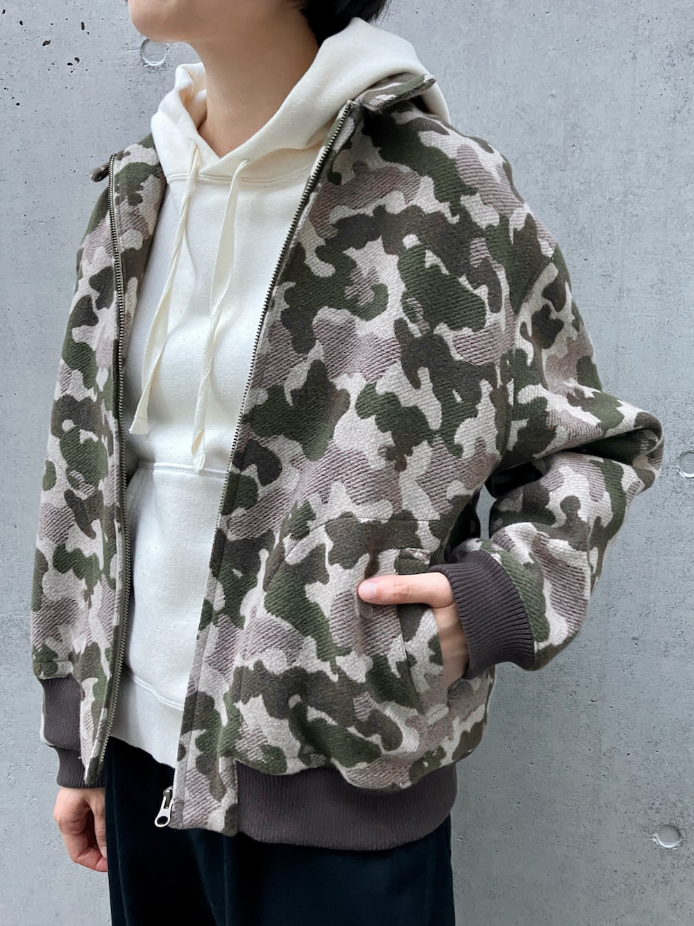 ホワイト系のパーカー、グリーン系のブルゾン、ブルー系のチノパンツを着用したレディースの秋コーディネートの4枚目の写真