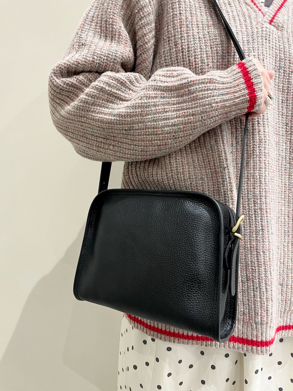 ホワイト系のTシャツ/カットソー、ブラック系のショルダーバッグ、ホワイト系のスカートを着用したレディースの冬コーディネートの4枚目の写真