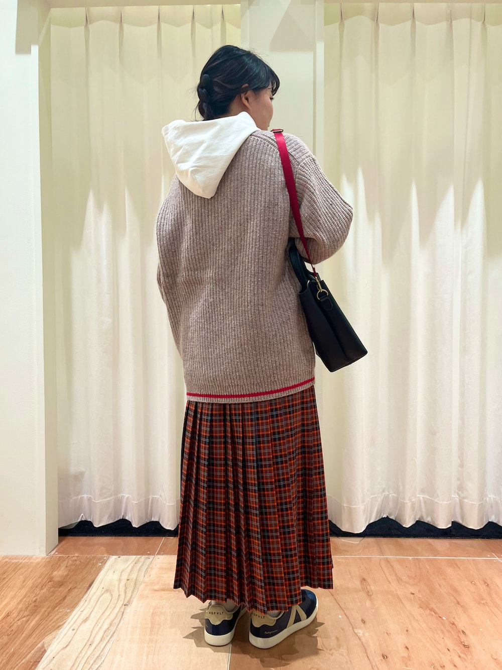 その他のニット/セーター、レッド系のスカート、ホワイト系のTシャツ/カットソーを着用したレディースの冬コーディネートの3枚目の写真