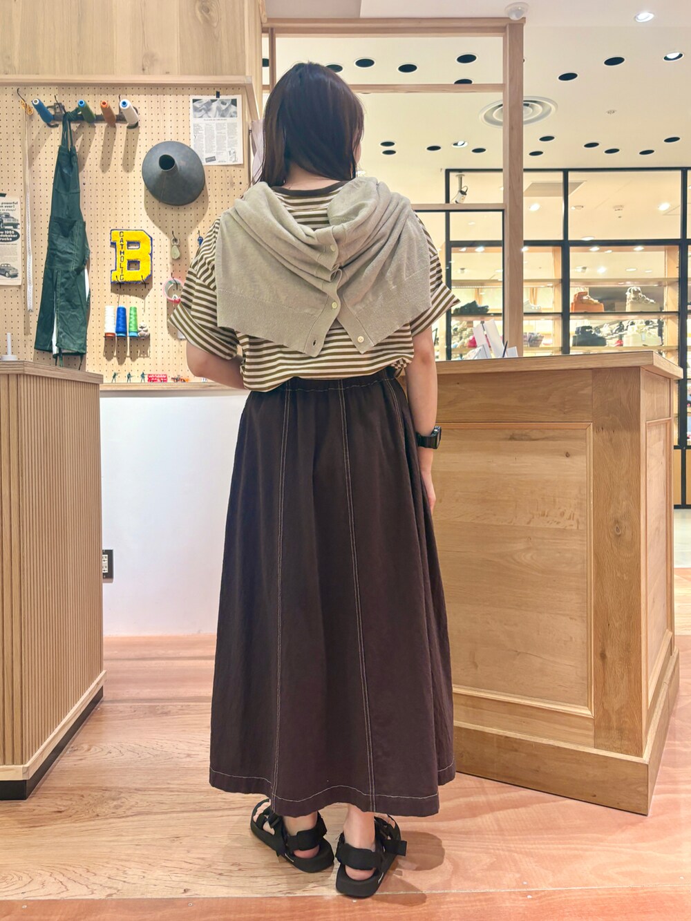 ベージュ系のカーディガン/ボレロ、ブラウン系のスカート、イエロー系のTシャツ/カットソーを着用したレディースの夏コーディネートの3枚目の写真