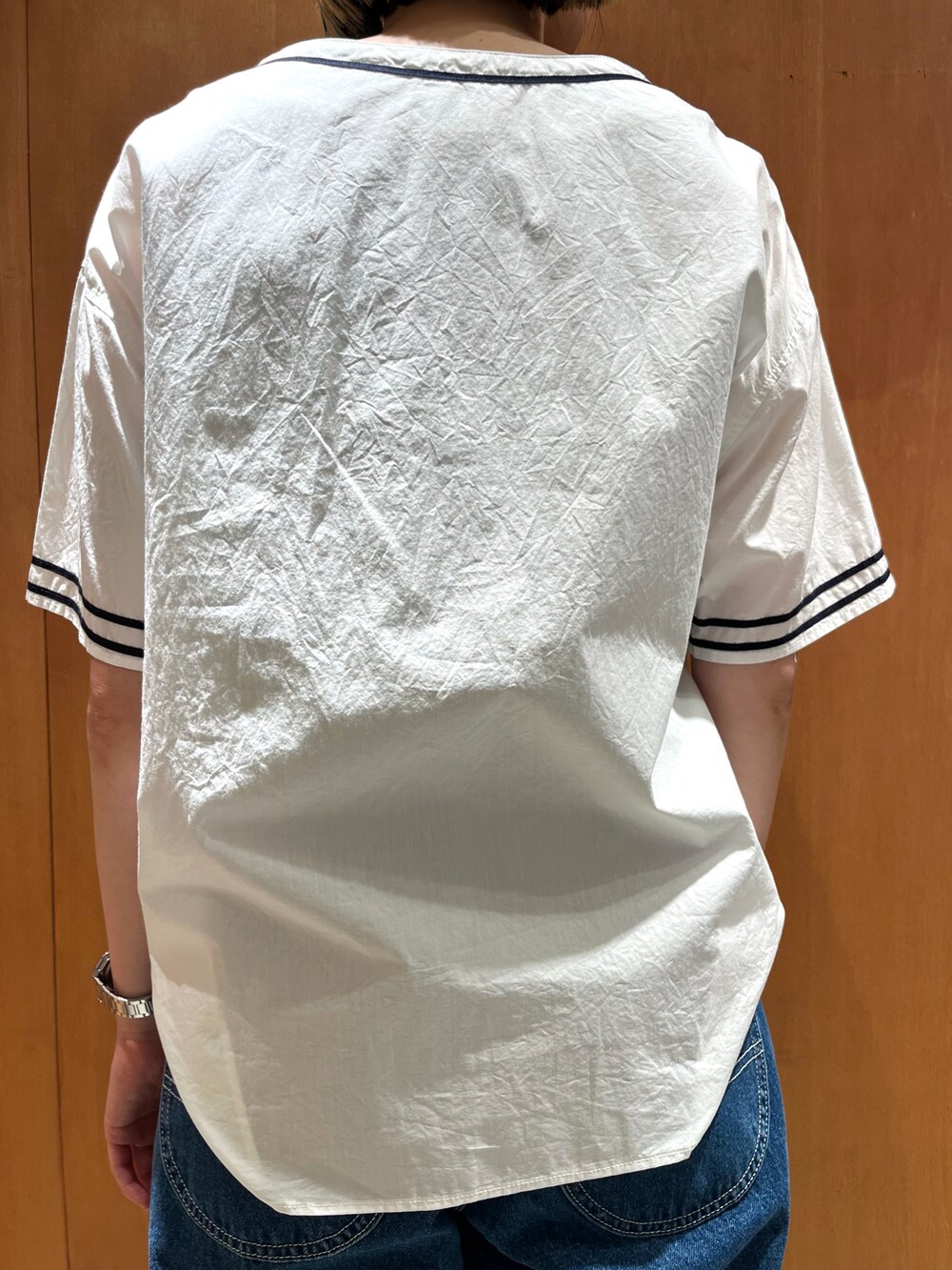 ブルー系のデニムパンツ、ホワイト系のシャツ/ブラウスを着用したレディースの夏コーディネートの3枚目の写真