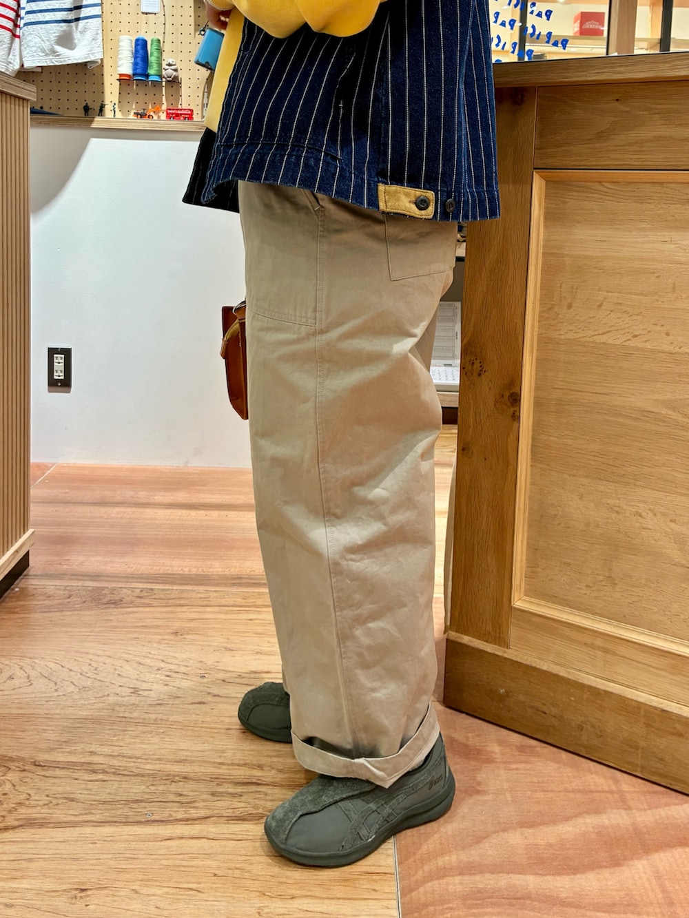 ホワイト系のTシャツ/カットソー、ブラウン系のショルダーバッグ、ベージュ系のチノパンツを着用したレディースの冬コーディネートの5枚目の写真