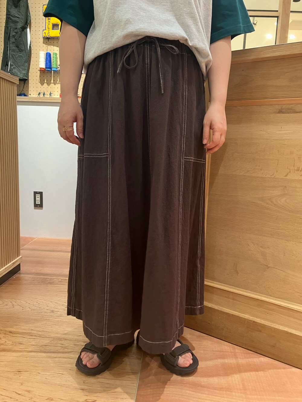 グリーン系のTシャツ/カットソー、ブラウン系のスカートを着用したレディースの夏コーディネートの4枚目の写真