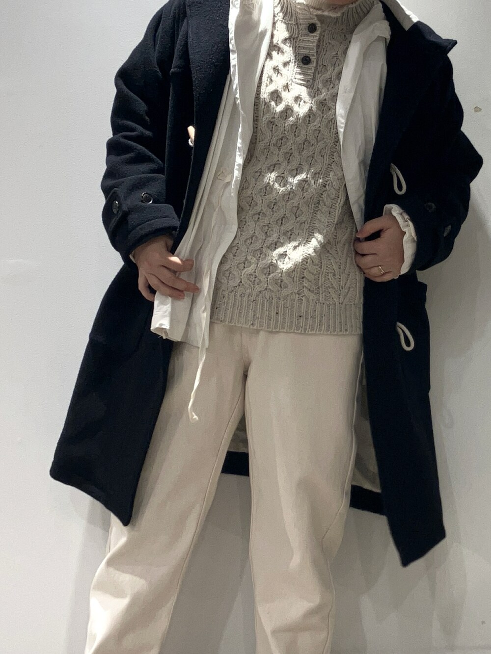 ホワイト系のニット/セーター、ホワイト系のデニムパンツ、ホワイト系のTシャツ/カットソーを着用したレディースの冬コーディネートの3枚目の写真