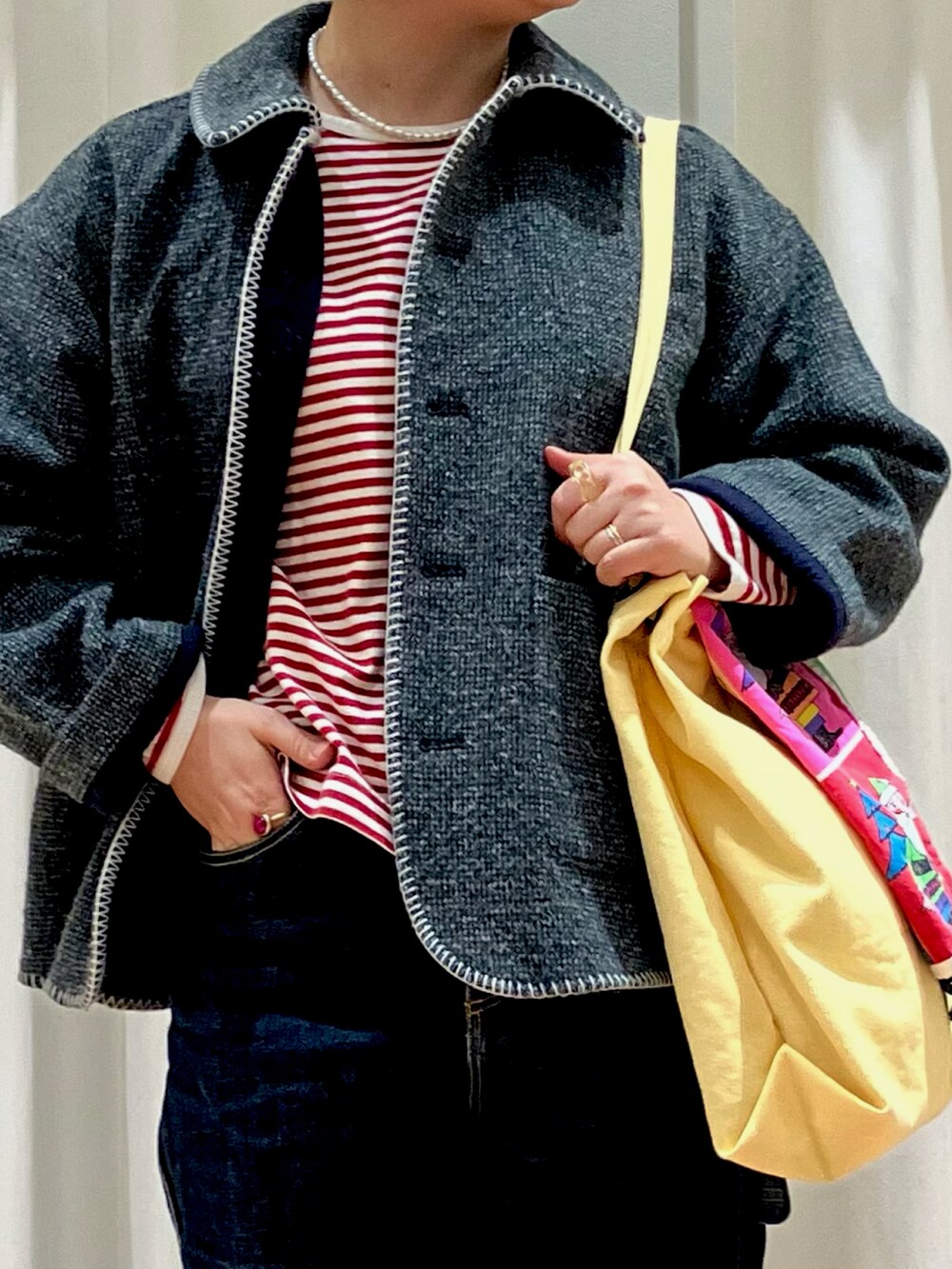 グリーン系のブルゾン、レッド系のTシャツ/カットソー、イエロー系のトートバッグを着用したレディースの冬コーディネートの3枚目の写真