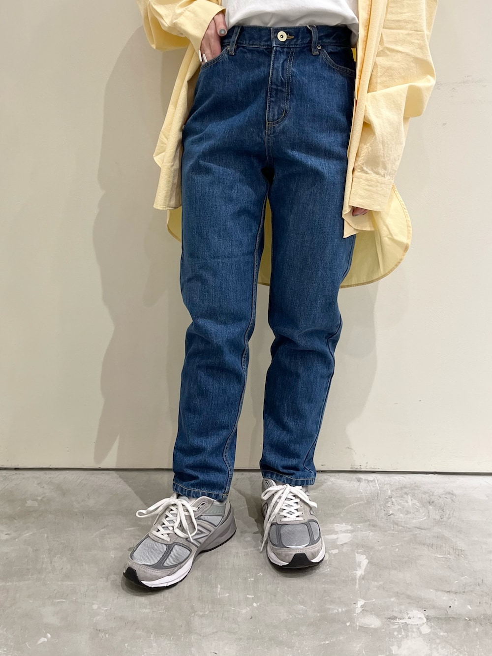 ブルー系のTシャツ/カットソー、イエロー系のシャツ/ブラウス、ブルー系のデニムパンツを着用したレディースの春コーディネートの5枚目の写真