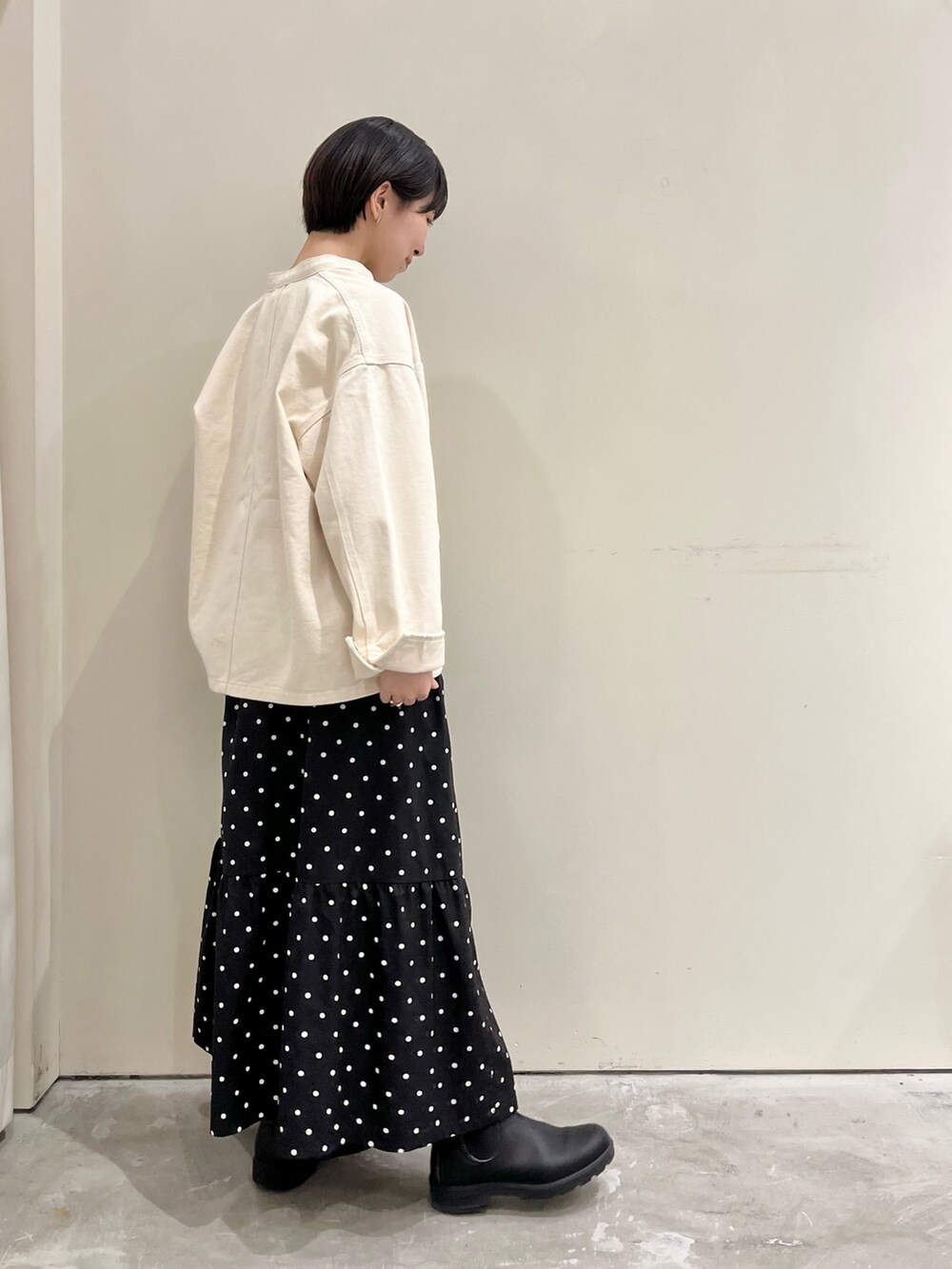 ホワイト系のカバーオール、ブラック系のスカート、グレー系のTシャツ/カットソーを着用したレディースの春コーディネートの3枚目の写真