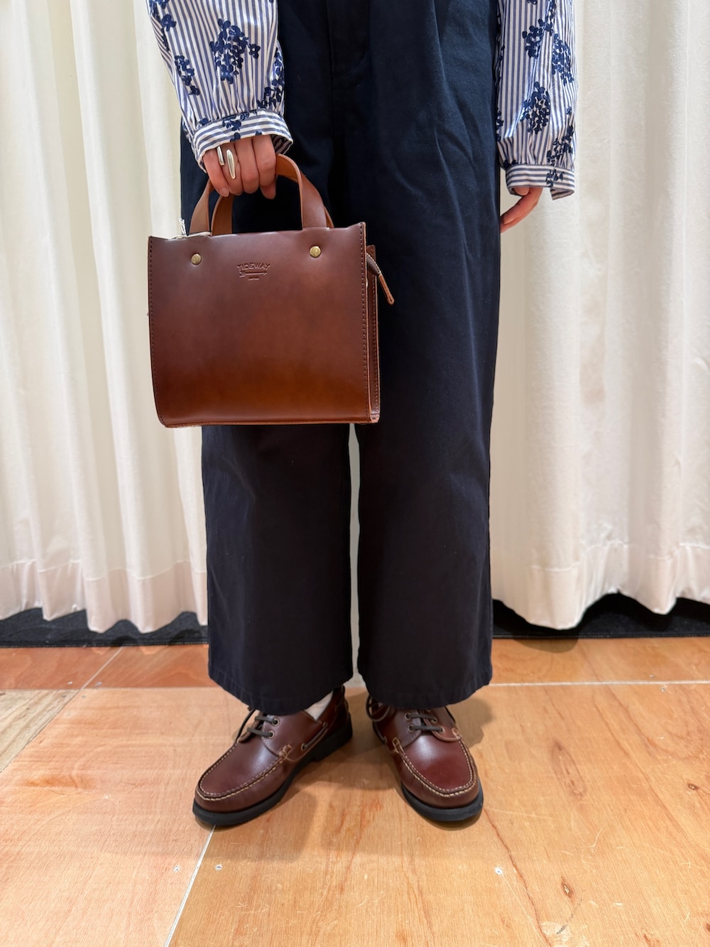 ブルー系のシャツ/ブラウス、ブルー系のチノパンツ、ブラウン系のショルダーバッグを着用したレディースの春コーディネートの6枚目の写真