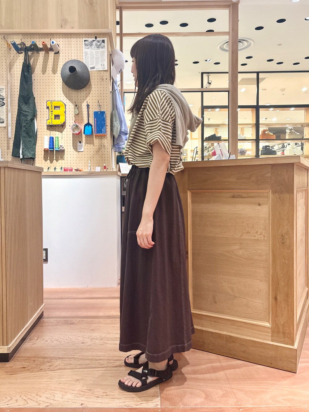 ベージュ系のカーディガン/ボレロ、ブラウン系のスカート、イエロー系のTシャツ/カットソーを着用したレディースの夏コーディネートの2枚目の写真
