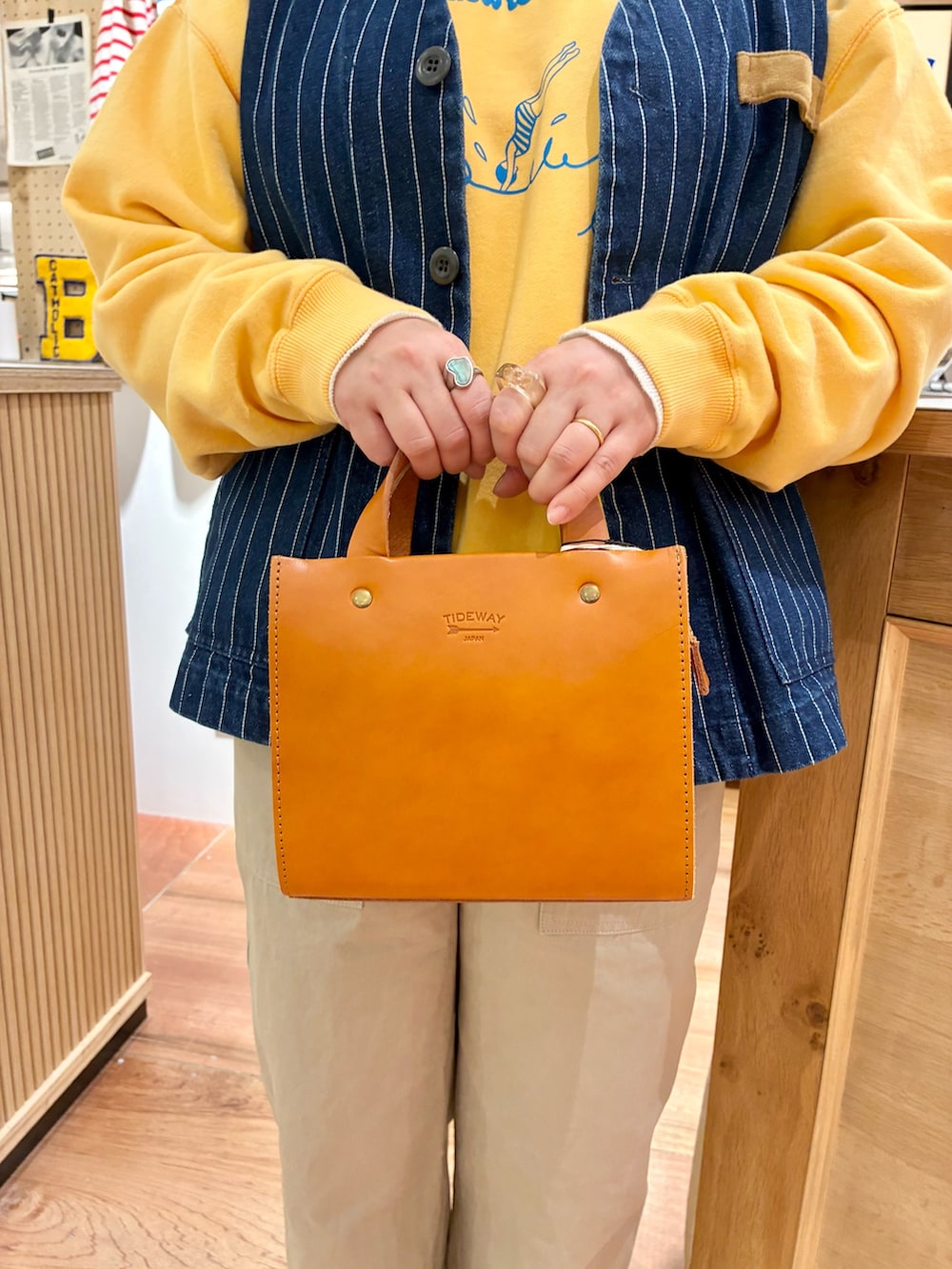 ホワイト系のTシャツ/カットソー、ブラウン系のショルダーバッグ、ベージュ系のチノパンツを着用したレディースの冬コーディネートの6枚目の写真