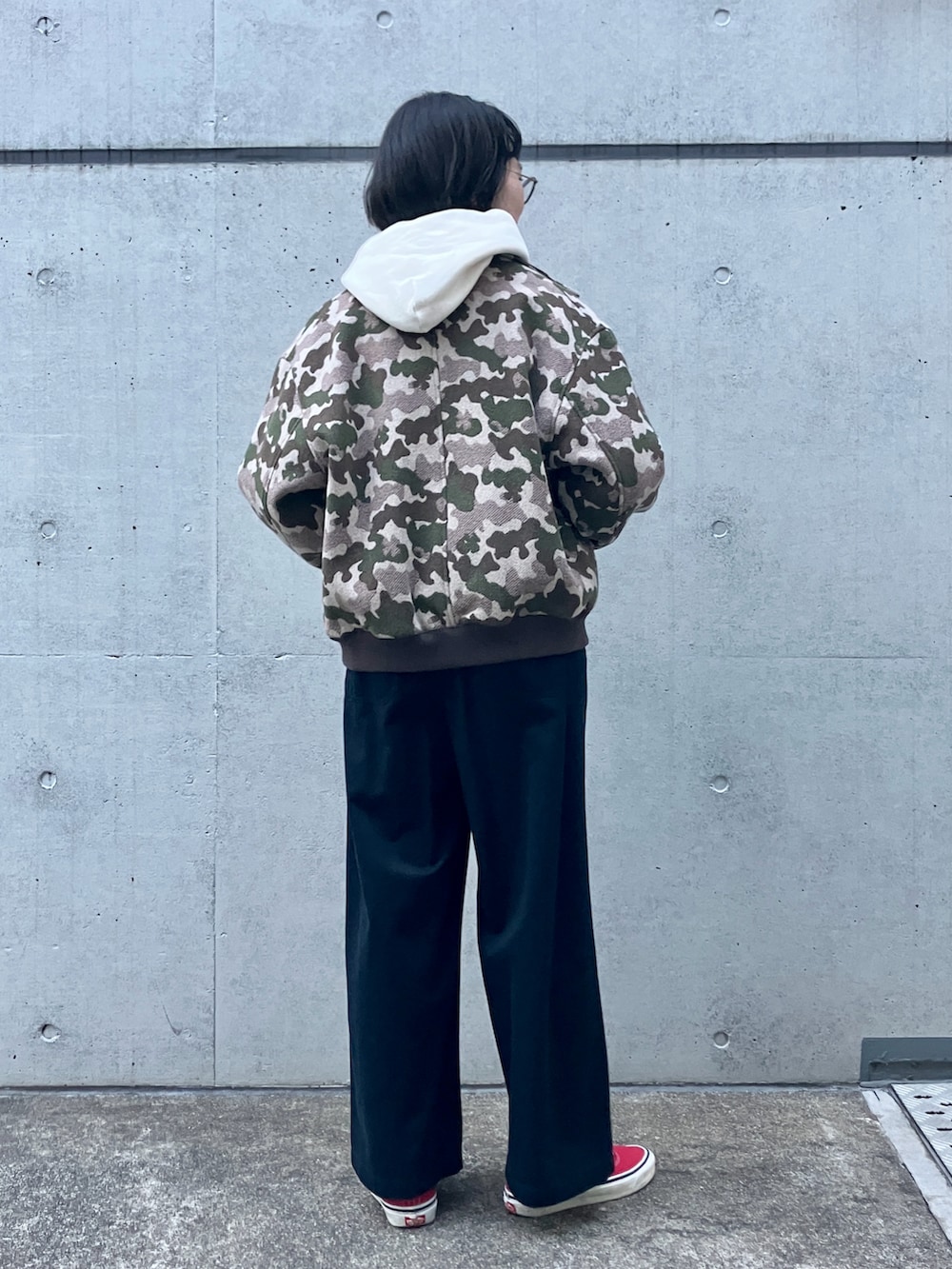 ホワイト系のパーカー、グリーン系のブルゾン、ブルー系のチノパンツを着用したレディースの秋コーディネートの3枚目の写真