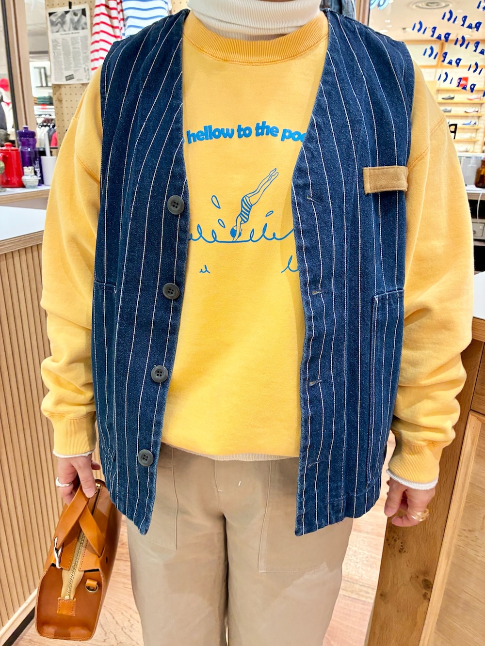 ホワイト系のTシャツ/カットソー、ブラウン系のショルダーバッグ、ベージュ系のチノパンツを着用したレディースの冬コーディネートの4枚目の写真