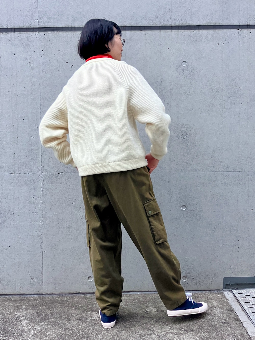 ホワイト系のニット/セーター、レッド系のTシャツ/カットソー、グリーン系のカーゴパンツを着用したレディースの秋コーディネートの3枚目の写真