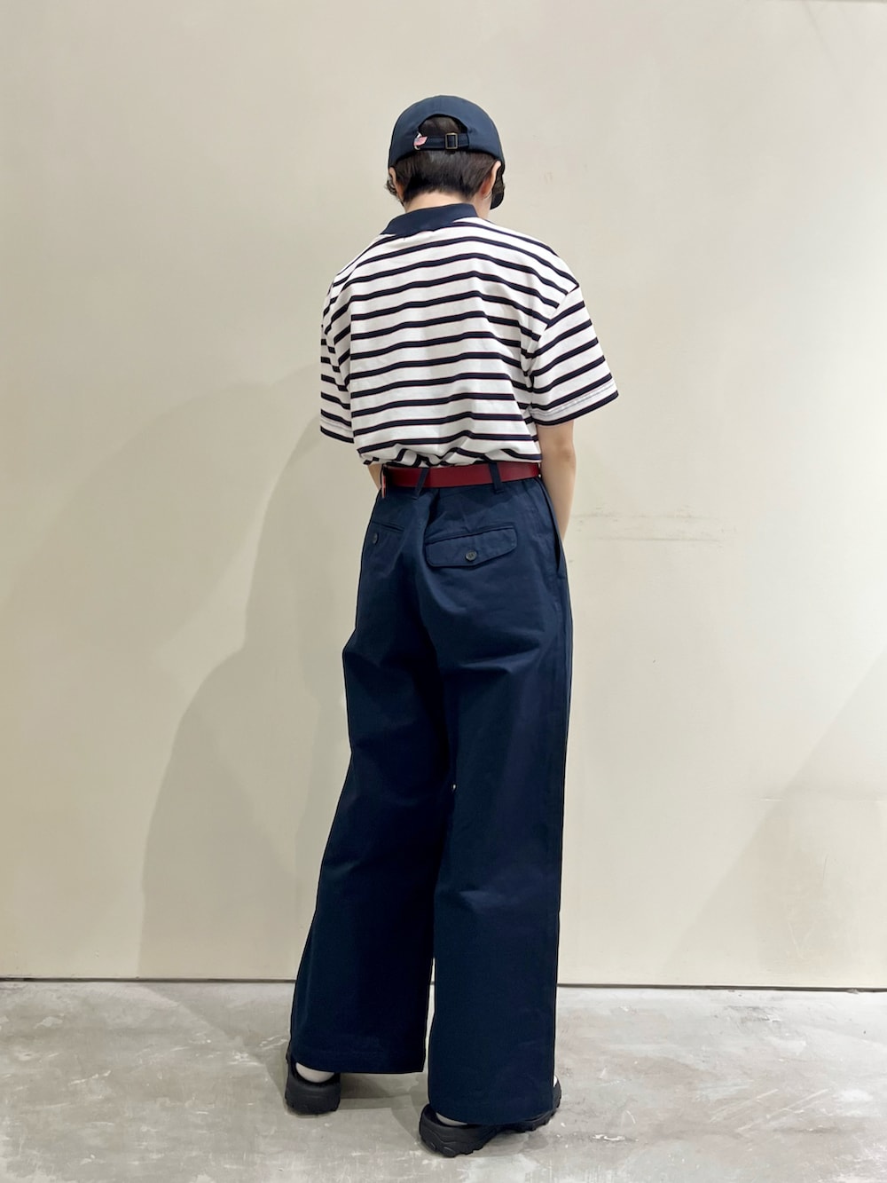 ホワイト系のTシャツ/カットソー、ブルー系のチノパンツ、レッド系のベルトを着用したレディースの春コーディネートの3枚目の写真