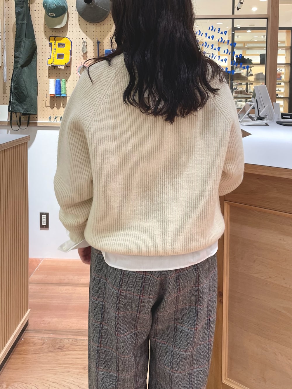 ホワイト系のシャツ/ブラウス、ホワイト系のニット/セーター、ブラウン系のショルダーバッグを着用したレディースの秋コーディネートの3枚目の写真