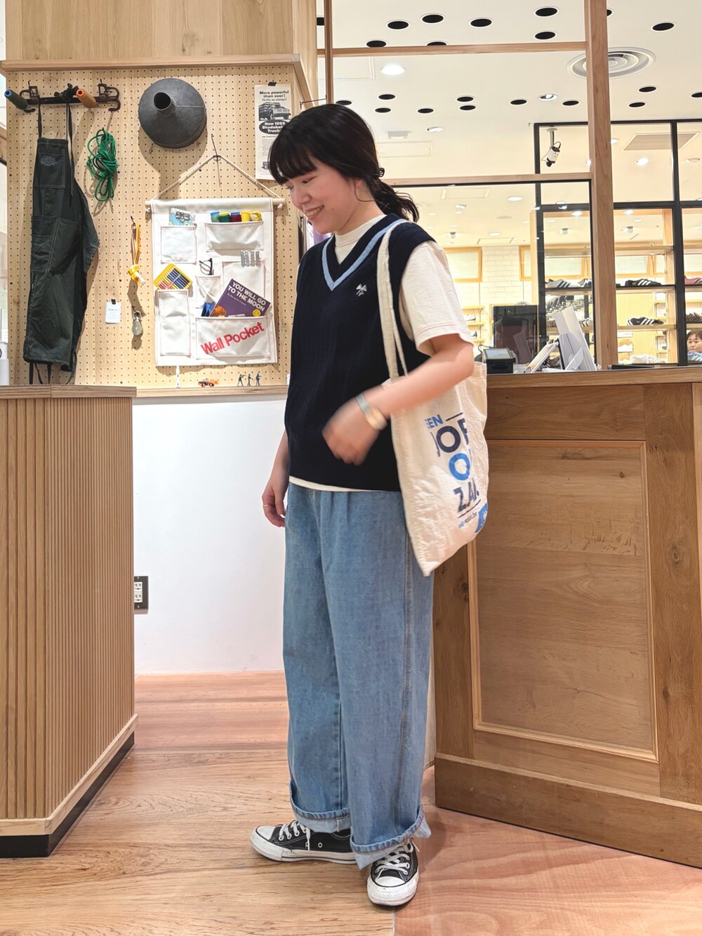 ブルー系のベスト、ホワイト系のTシャツ/カットソー、ブルー系のデニムパンツを着用したレディースの春コーディネートの2枚目の写真