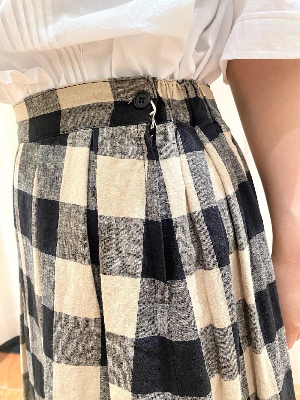 ホワイト系のシャツ/ブラウス、ベージュ系のベスト、ブラック系のスカートを着用したレディースの夏コーディネートの6枚目の写真