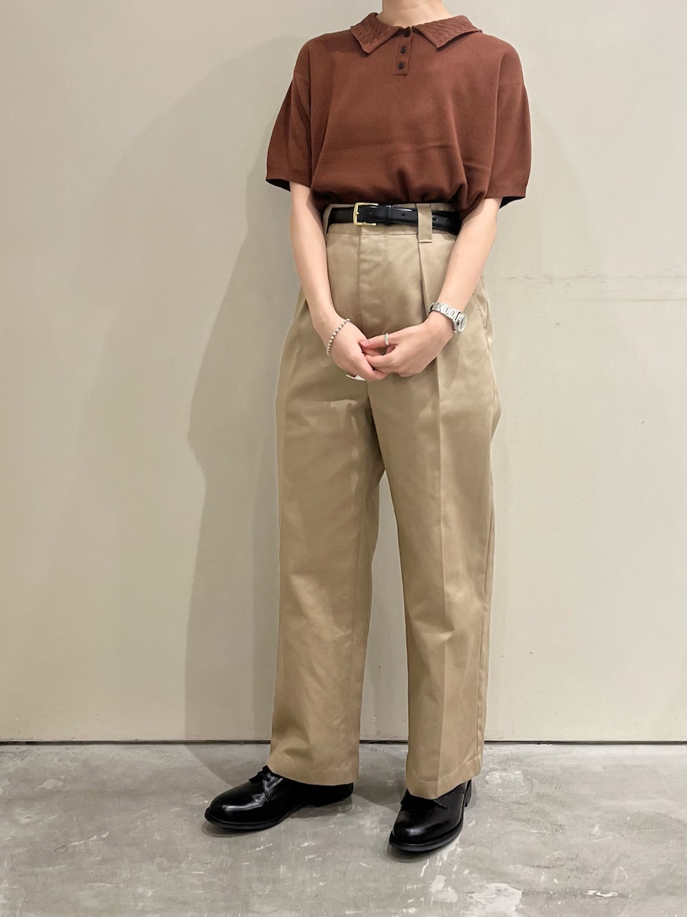 ブラウン系のポロシャツを着用したレディースの春コーディネートの2枚目の写真
