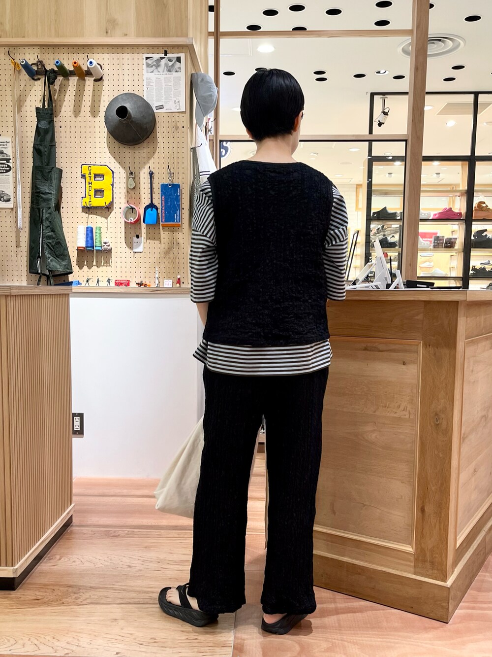 ブラック系のベスト、グリーン系のTシャツ/カットソー、ブラック系のその他パンツを着用したレディースの夏コーディネートの3枚目の写真