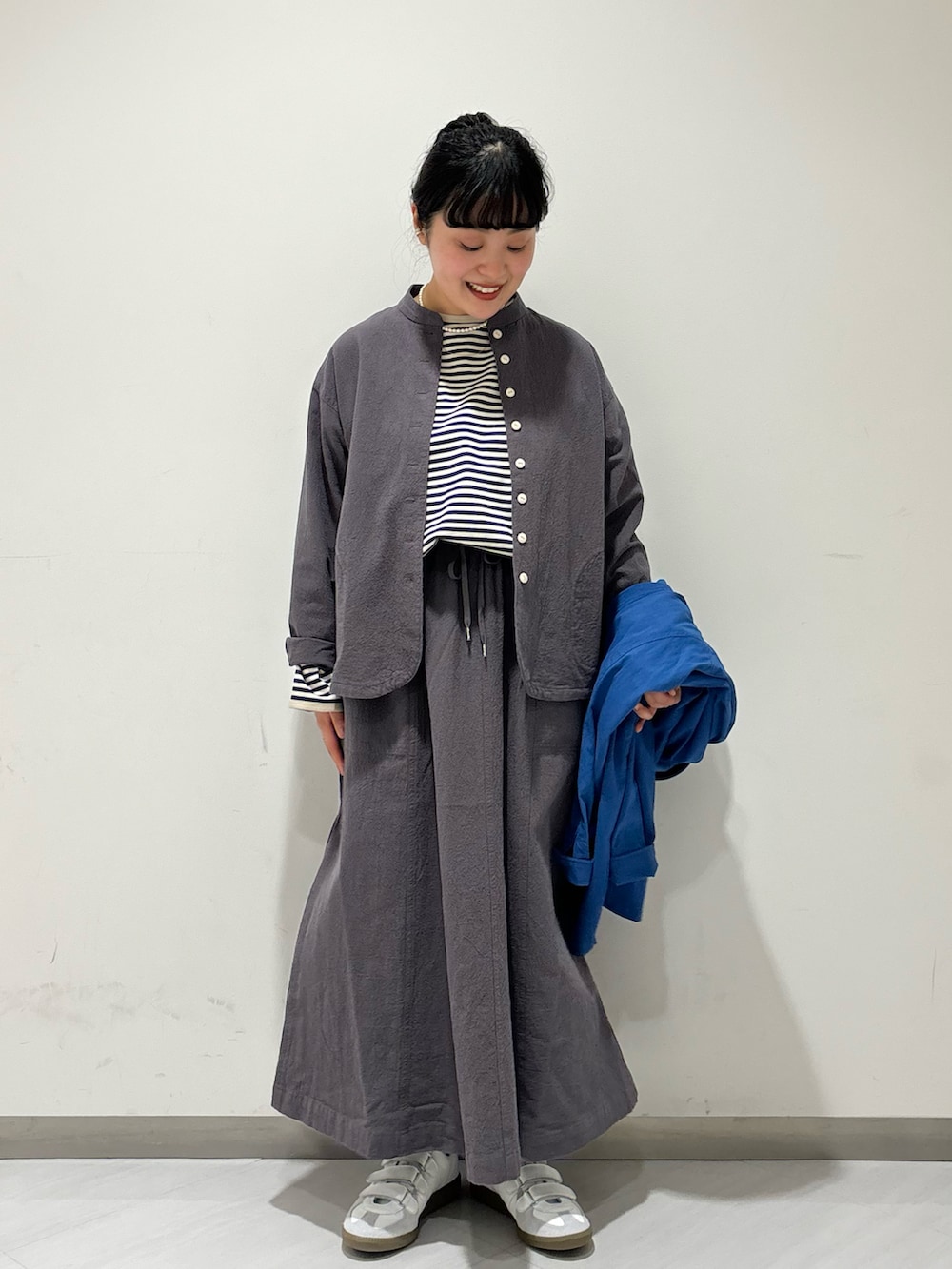 グレー系のシャツ/ブラウス、ブルー系のTシャツ/カットソー、グレー系のスカートを着用したレディースの春コーディネートの2枚目の写真