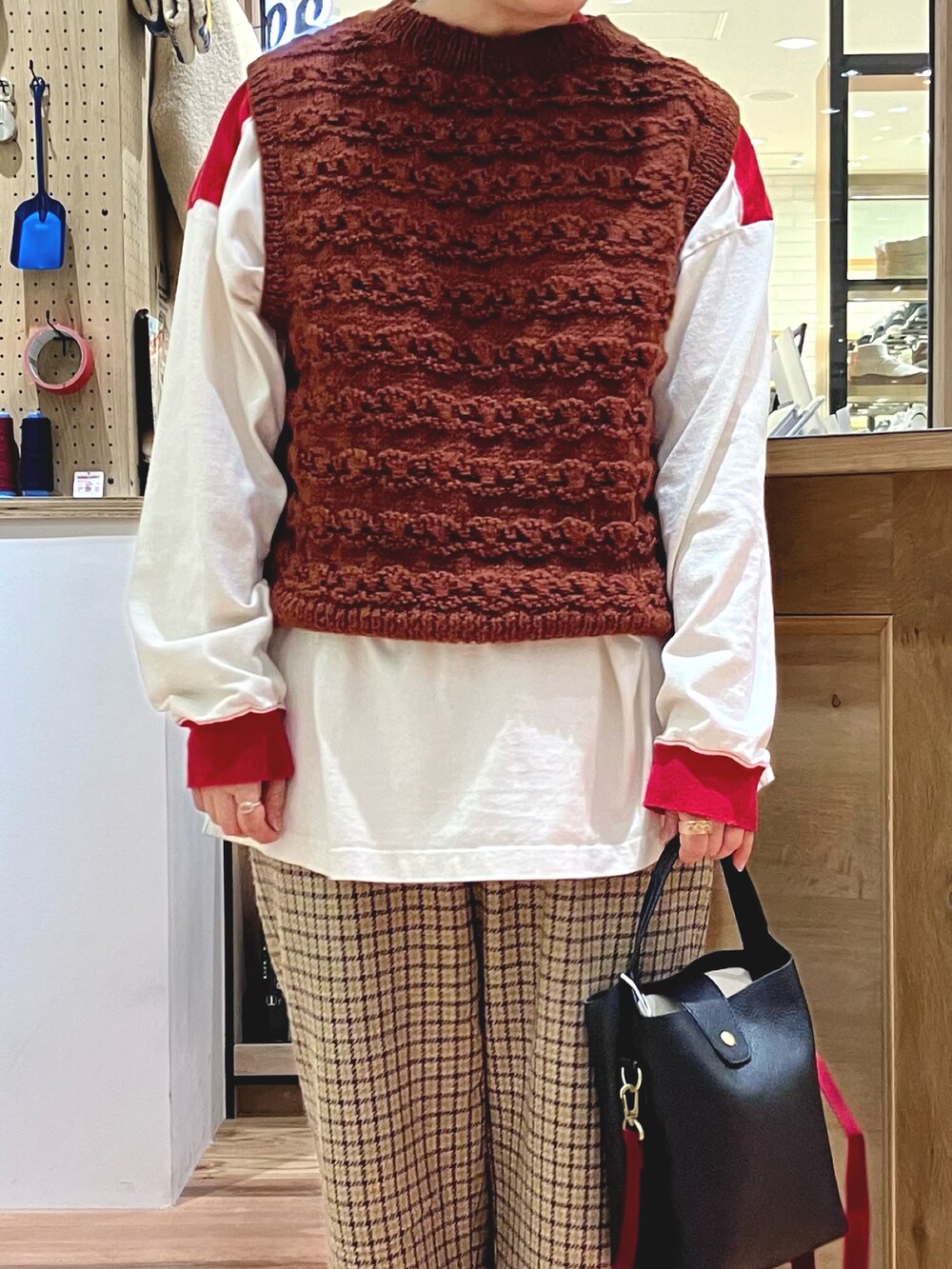 グリーン系のモッズコート、ブラウン系のベストを着用したレディースの秋コーディネートの3枚目の写真