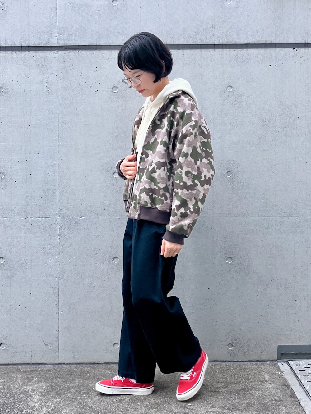 ホワイト系のパーカー、グリーン系のブルゾン、ブルー系のチノパンツを着用したレディースの秋コーディネートの2枚目の写真