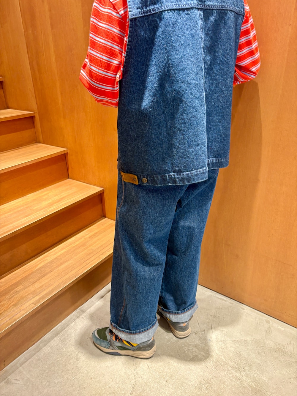 ブルー系のベスト、ブルー系のデニムパンツ、オレンジ系のTシャツ/カットソーを着用したレディースの春コーディネートの5枚目の写真